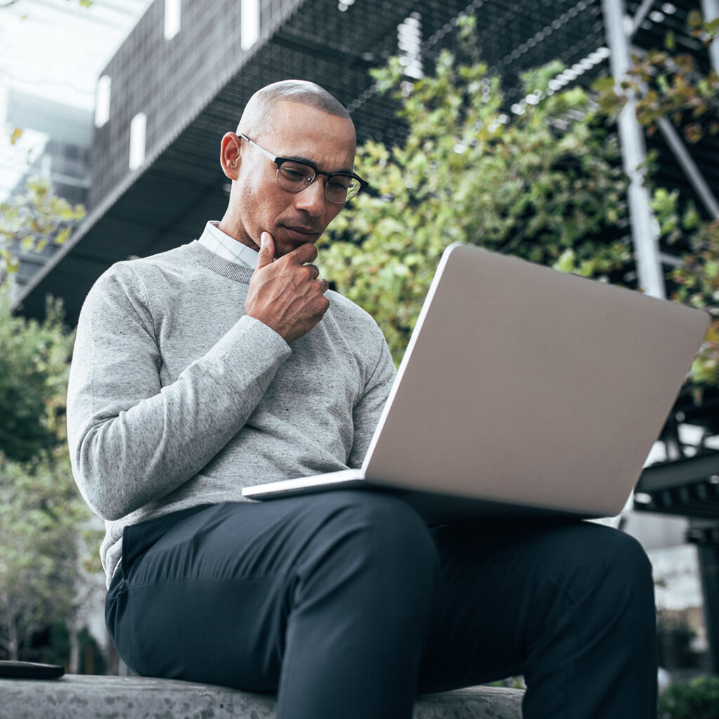 A building manager checking his laptop while outside