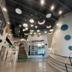 Modern, well-lit hallway inside S. Christa McAuliffe S.T.E.M. Academy, optimized with Colorado Controls building automation